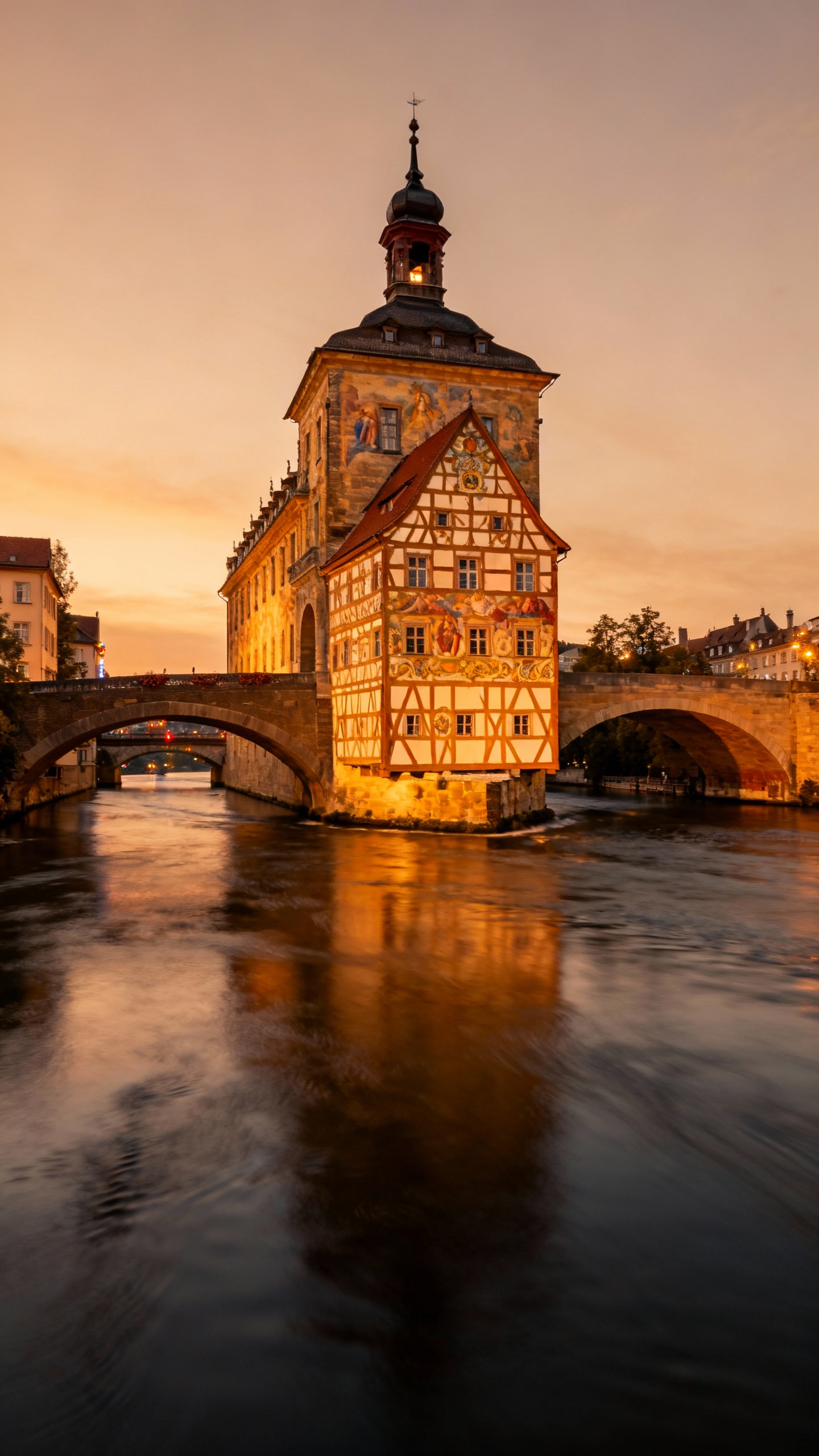 Altes Rathaus over river at dusk, reflections, ornate frescoed facade